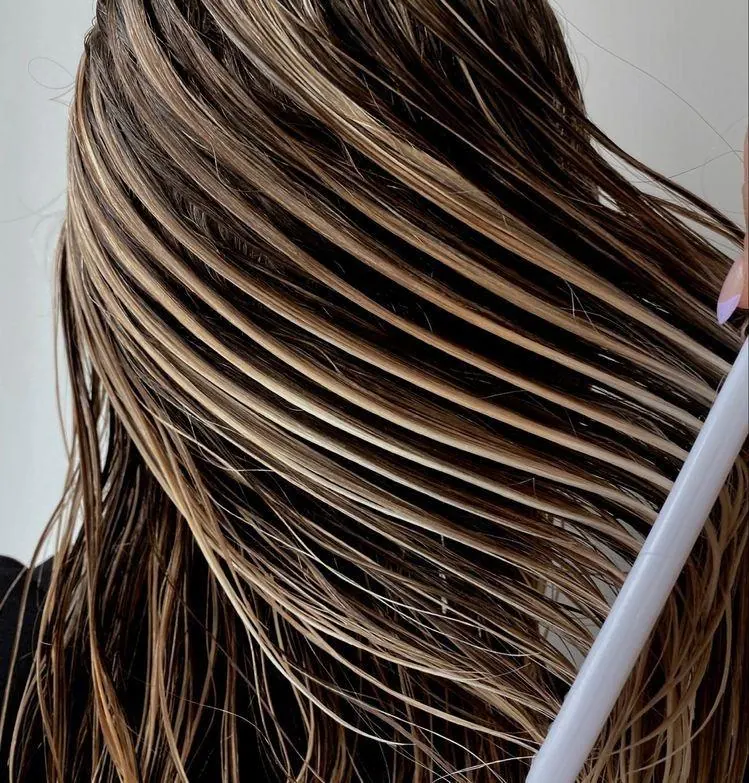 Product brushed through separated sections of wet hair